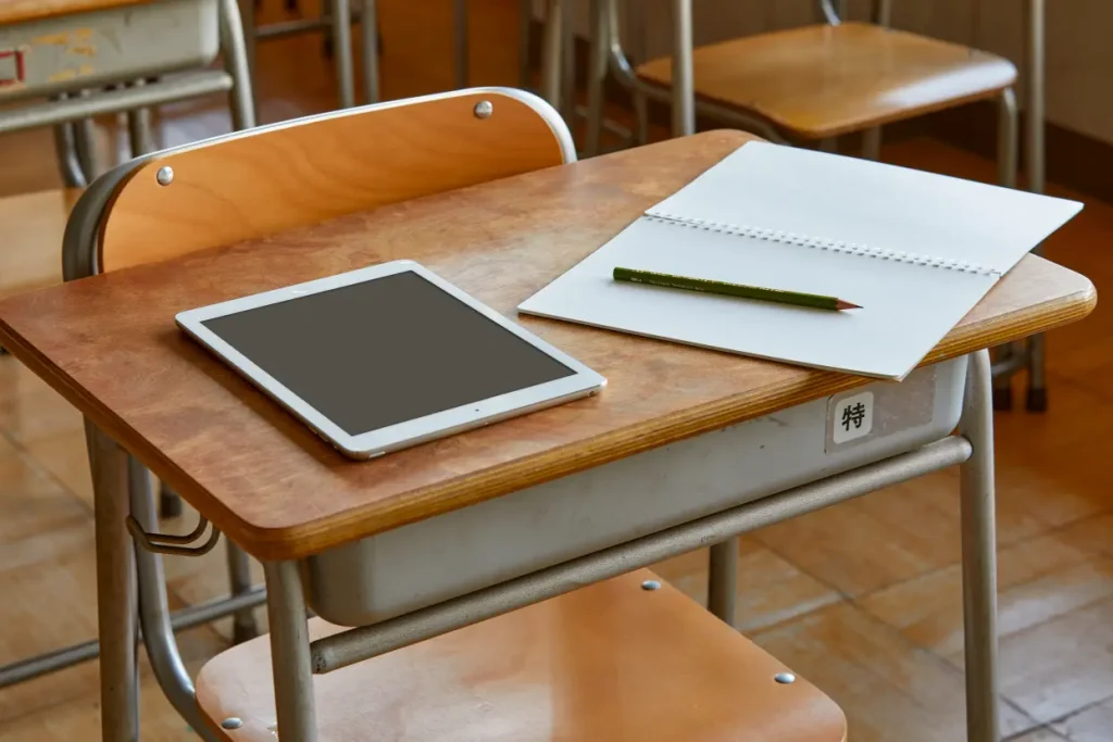 学校の教室の机とノート